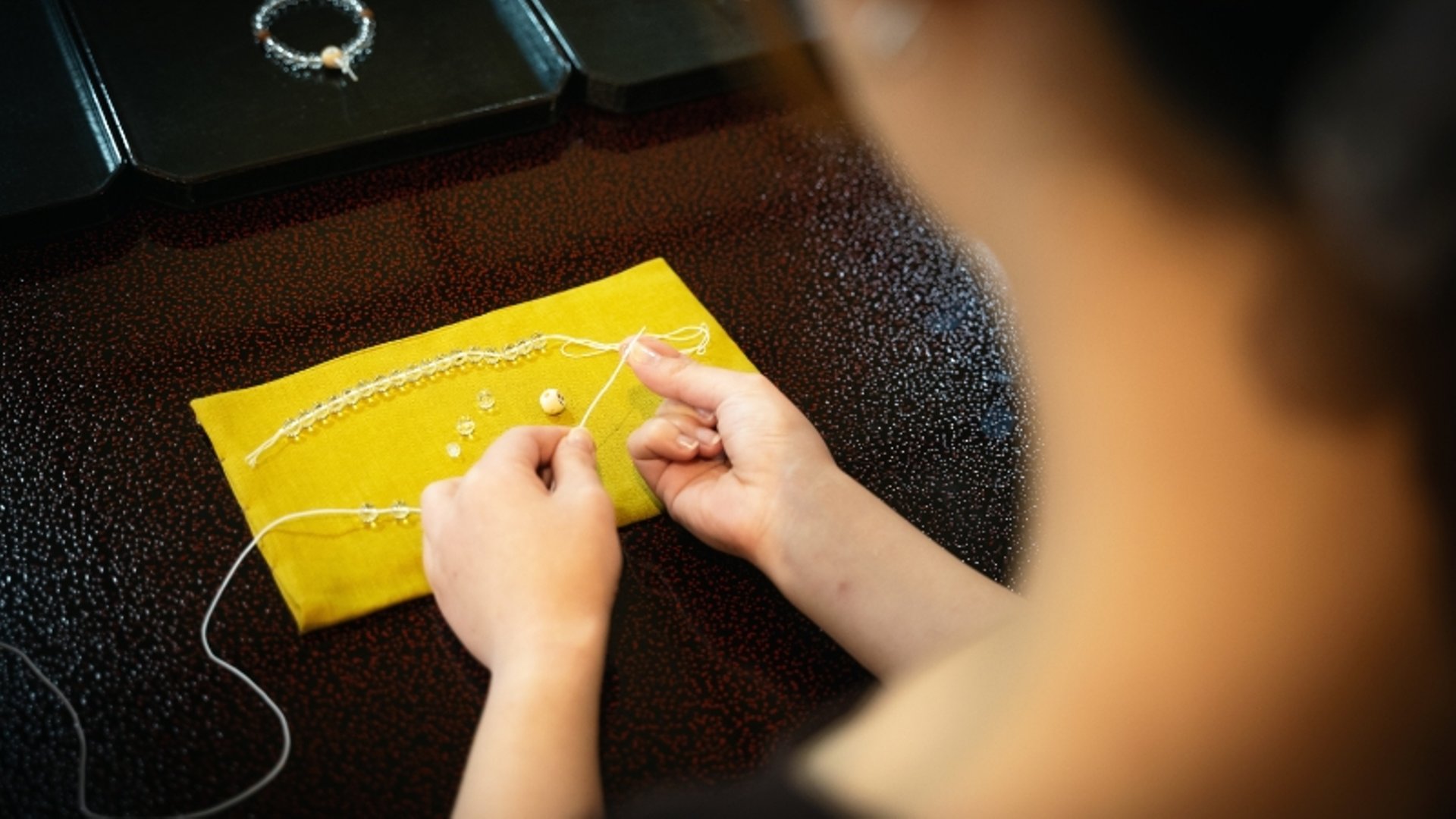 A photo of prayer bracelet making